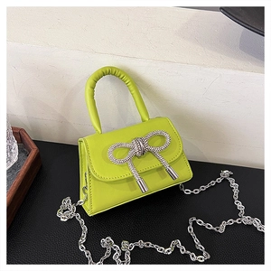 Gros plan du mini sac en cuir PU vert citron avec un nœud en strass brillant et chaîne