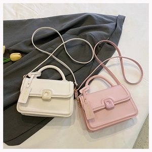 Detail of minimalist cream and pink crossbody bags with fashion tags and tulips