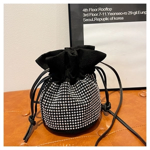 Detailed view of black suede drawstring bucket bag with silver rhinestone embellishments