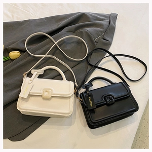 Detail of elegant black and white leather handbags with metal turn-lock and fashion tag