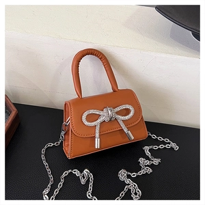 Détail du mini sac bandoulière marron avec nœud en strass étincelant et chaîne argentée