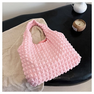 Detailed view of bubble pleated texture on a bright pink tote bag for women
