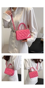 Detail view of rose pink crossbody bag featuring 3D triangle quilting and woven handles