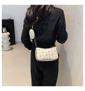 Detailed back view of beige monogram crossbody bag with round coin purse and wide strap