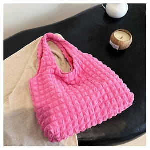 Close-up of pink puffy bubble textured fabric on a stylish large shoulder handbag