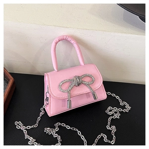 Détail du mini sac rose avec un nœud en strass argentés et une bandoulière chaîne