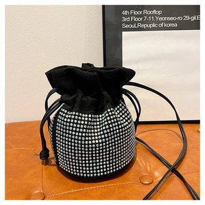 Detail of a black faux suede bucket bag with sparkling silver rhinestone embellishments