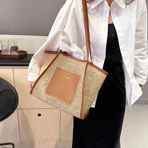 Large beige woven straw tote bag with brown leather straps for beach and summer travel