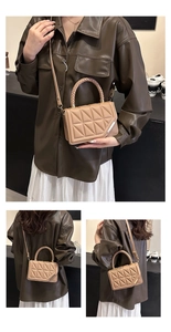 Close-up of khaki quilted crossbody bag with braided handle and gold metal clasp