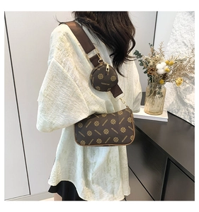 Detail of dark brown printed crossbody bag set with wide strap on female model
