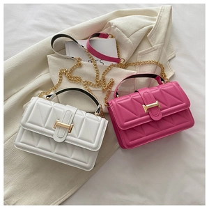 Detailed shot of white and rose red quilted handbags with golden H-buckle and chain strap