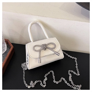 Détail du nœud argenté sur le mini sac à bandoulière blanc avec bandoulière chaîne