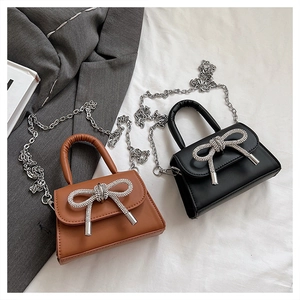 Détail des mini sacs à chaîne avec nœuds en cristal étincelants en noir et marron