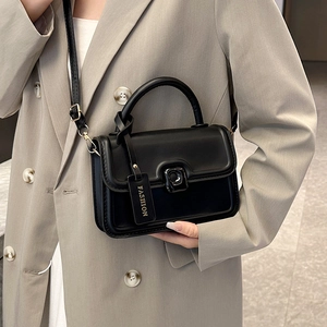 Chic black matte leather crossbody bag with top handle and decorative Fashion tag