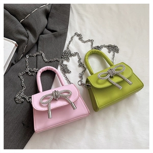 Détail de mini sacs en cuir avec nœuds en strass en rose et vert lime couleurs