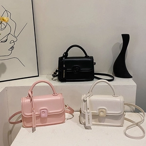 Three minimalist PU leather square handbags in black, pink, and white on a modern display