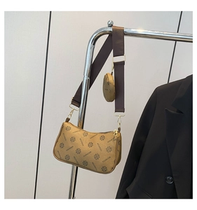Detail of trendy crossbody bag set featuring floral monogram print and wide fabric strap