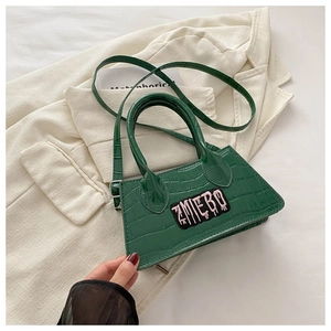 Detail of dark green crocodile texture handbag with TMLIEBO embroidery on a beige blazer