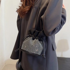 Fashionable black faux suede bucket bag with silver stud accents and drawstring closure