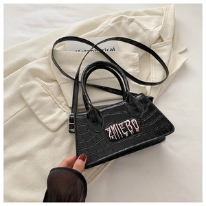 Detailed view of crocodile texture bag with pink AMIEBO embroidery on a blazer