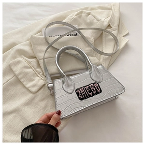 Silver crocodile texture bag with ZMIEBO embroidery patch on a beige blazer