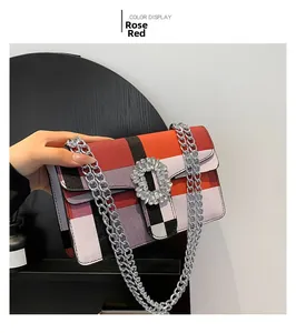 Détail du sac à rabat à carreaux rose rouge avec boucle en cristal et chaîne argent