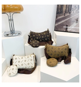 Detailed display of three vintage monogram hobo bags with round coin purses on a display stand