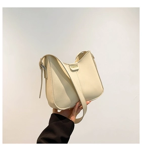 Detail of cream hobo bag showing adjustable strap and fashion metal buckle closure