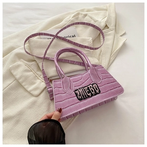 Detail view of lavender crocodile texture bag with ZMIEBO embroidery and shoulder strap