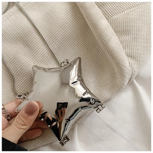 Detailed macro view of the shiny silver star-shaped mini bag with a fine metal chain strap
