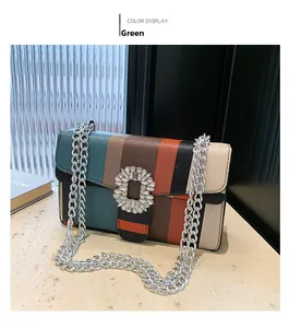 Détail du sac à main rayé multicolore avec boucle en cristal et bandoulière chaîne