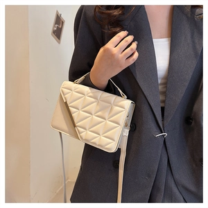 Quilted off-white crossbody bag featuring a golden metal bar and textured finish