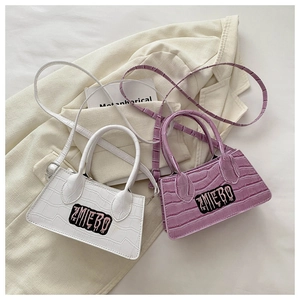 Close-up of white and purple crocodile pattern handbags with ZMIEBO lettering detail