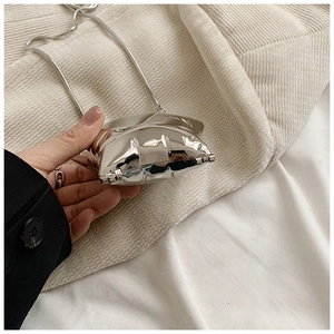 Close-up of a mini silver metallic evening clutch with a sleek snake chain strap