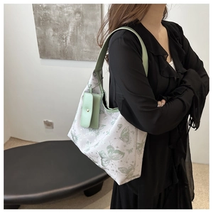 Détail du sac cabas blanc avec imprimé papillon vert et petite pochette assortie