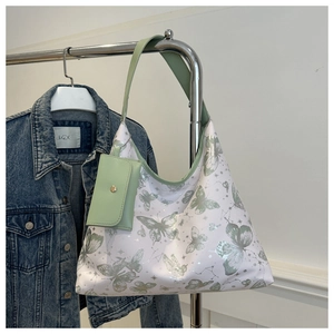 Détail du sac cabas blanc à motifs papillons avec anses vertes et mini pochette assortie