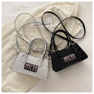 Detail view of silver and black crocodile embossed crossbody bags with ZMEBO lettering