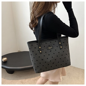 Detail of grey canvas tote bag with black polka dots and butterfly embroidery textures