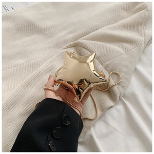 Detailed close-up of a mini star-shaped hard shell clutch bag with gold mirror finish