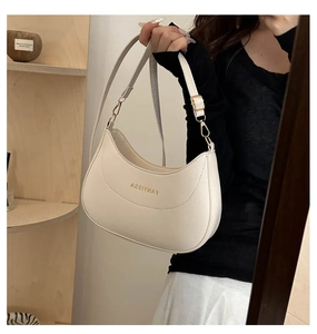 Détail du sac hobo blanc crème avec boucles dorées et texture de cuir raffinée