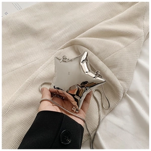 Close-up of star-shaped silver metallic mini bag with reflective mirror finish and chain