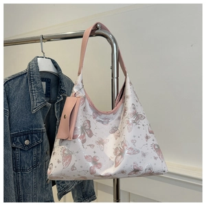 Détail du sac cabas blanc avec imprimés papillons et petit porte-monnaie rose assorti