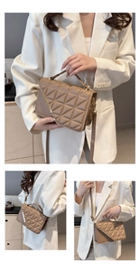 Detail showing triangle quilting pattern and golden L-shaped metal bar on tan crossbody bag