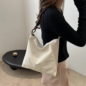 Chic cream tote bag with stylish wooden bead shoulder strap and pleated texture