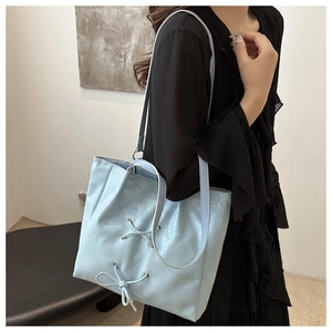 Detailansicht der hellblauen Tote Bag mit Metallglanz, Schnürung und Schleifenakzent
