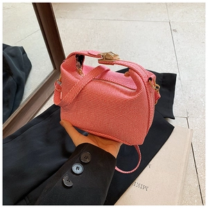 Detail of red and pink striped fabric mini bag with unique knotted handle and gold clasp