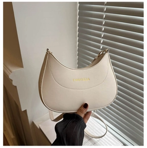 Détail du sac à bandoulière demi-lune blanc crème avec logo doré et lanière