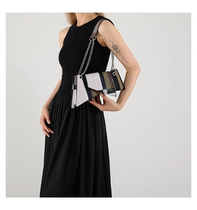 Detail of color-block minimalist shoulder bag with geometric panels and chain strap