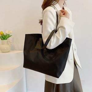 Minimalist black nylon tote bag with leather straps for daily commute and business travel