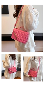 Detail of pink quilted PU leather crossbody bag featuring gold metal bar and textured finish